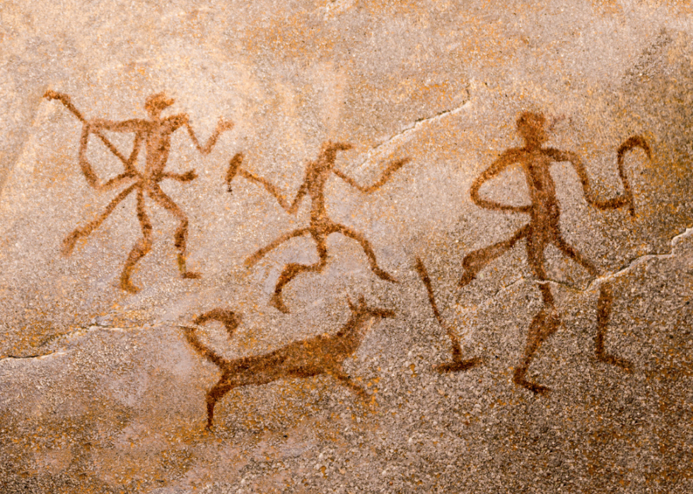 Cave painting depicting hunters with dog