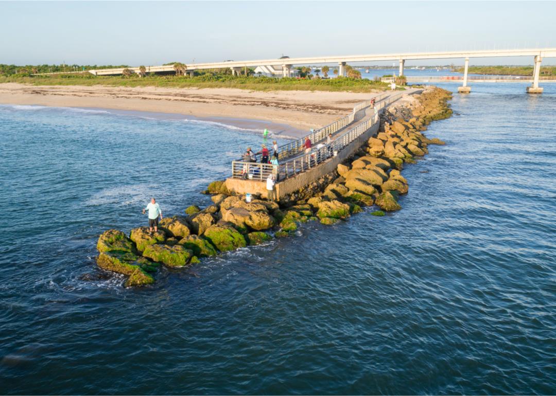 A group of people gathered on an pier at a beach in Roseland, Florida.