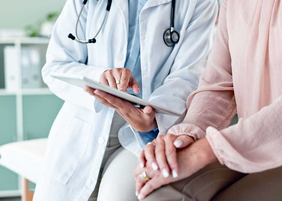 Doctor and patient reviewing information on tablet.