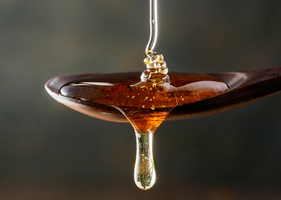 Close up pouring honey on spoon.