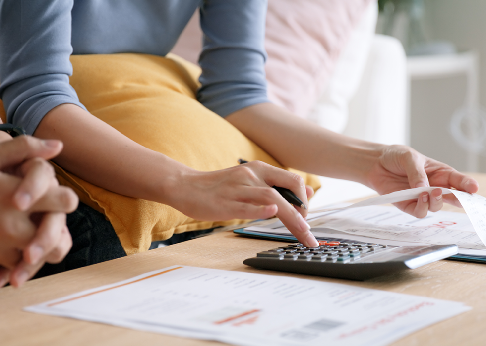 Two people sitting on sofa reviewing receipts together.