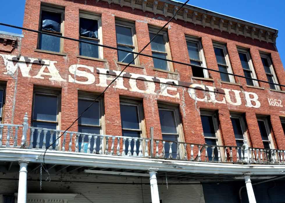 Exterior detail of painted brick sign and windows of The Old Washoe Club building.