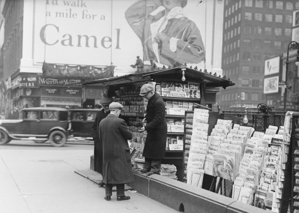 Man buys a newspaper at a newsstand on Times Square
