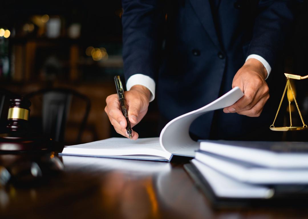 Attorney standing at desk writing in document