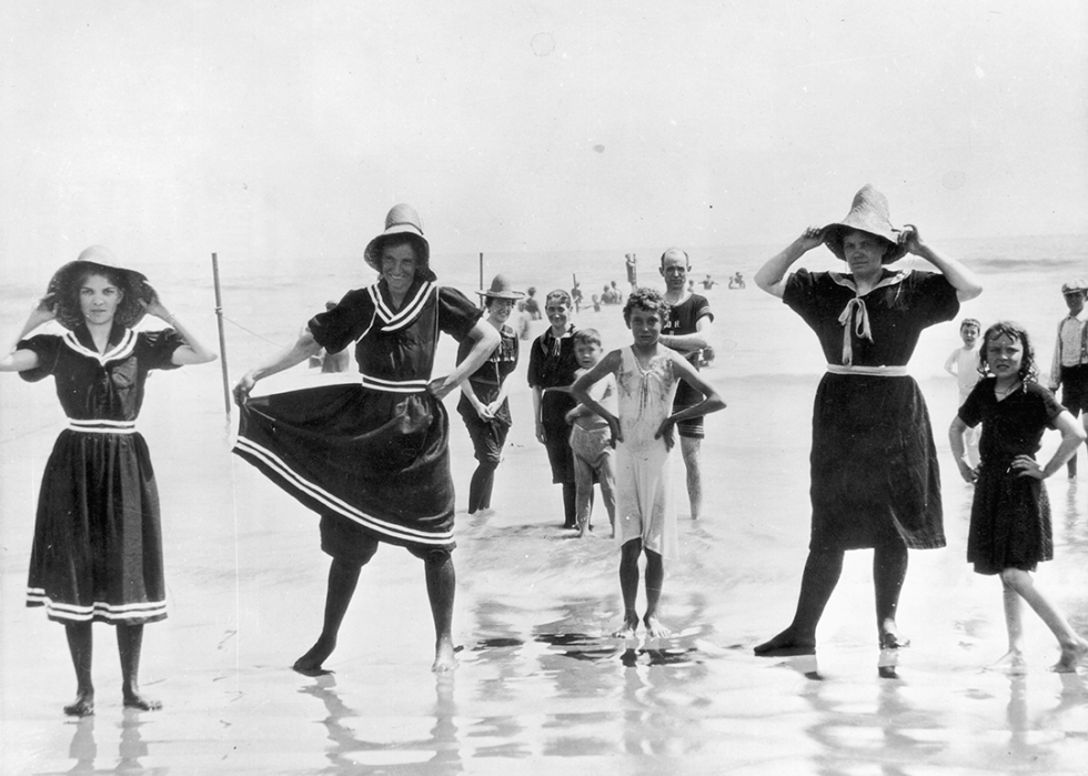 Holidaymakers posing in bathing suits in the ocean surf.