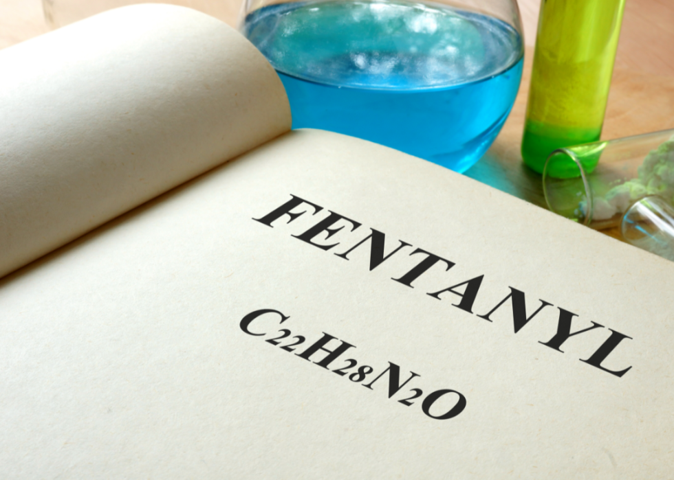 Book with fentanyl and test tubes on a table.