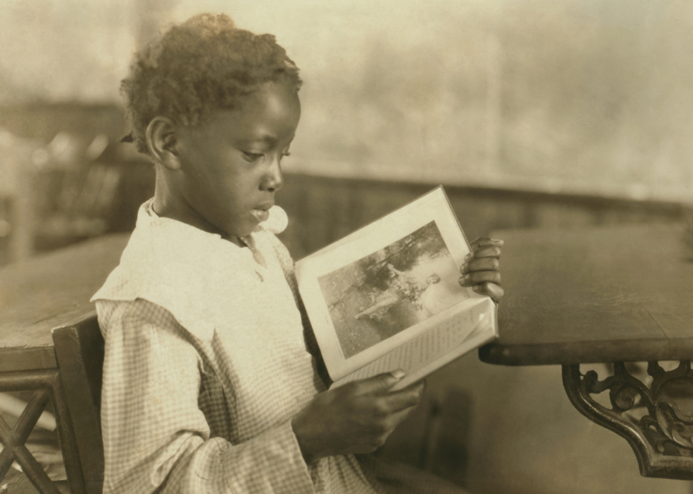 Young girl reading at desk.
