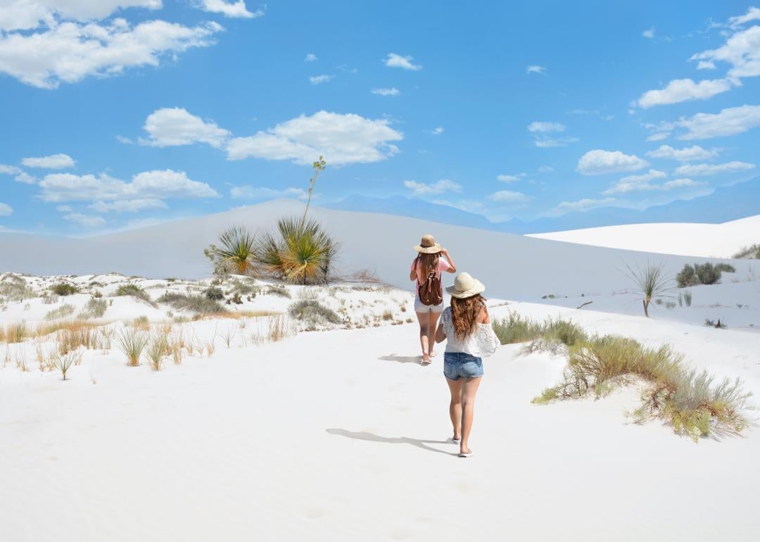Tourists walking on sand dunes.
