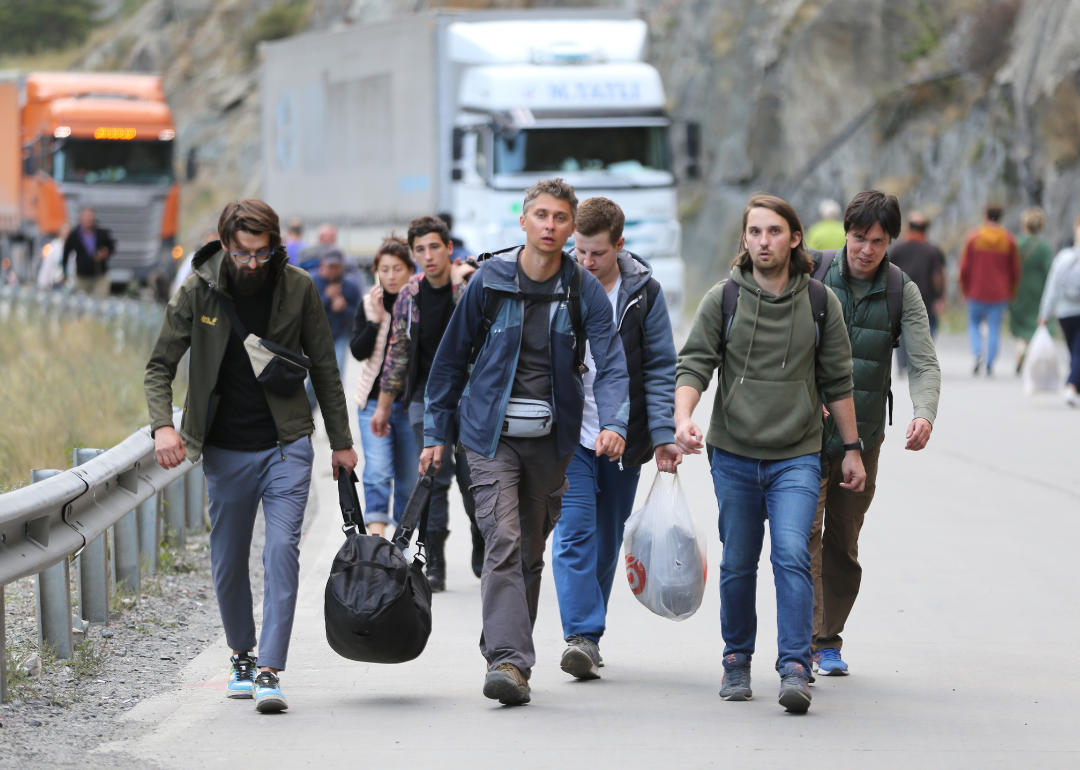 Russians carrying bags attempt to cross border into Georgia.