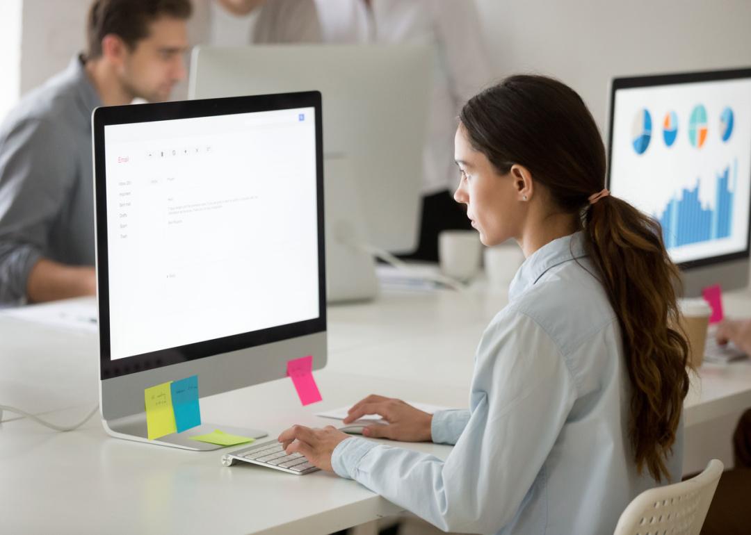 Woman working at desktop computer in office.