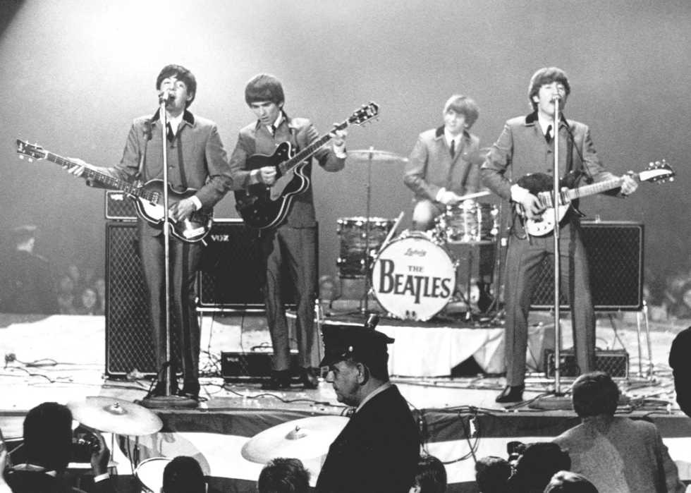 The Beatles perform onstage.