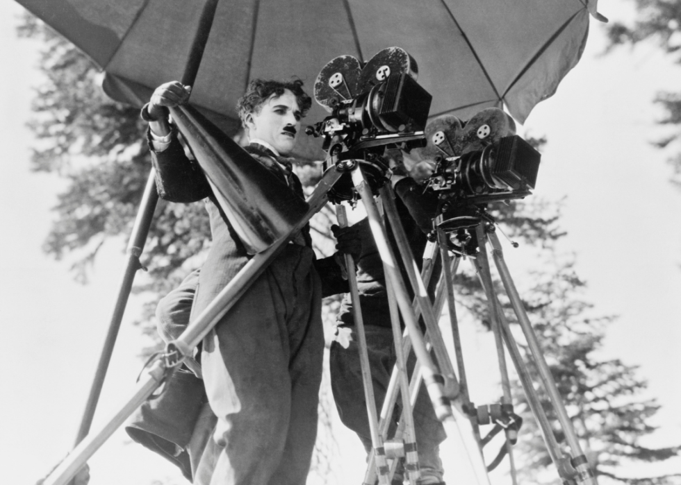Charlie Chaplin behind movie camera.