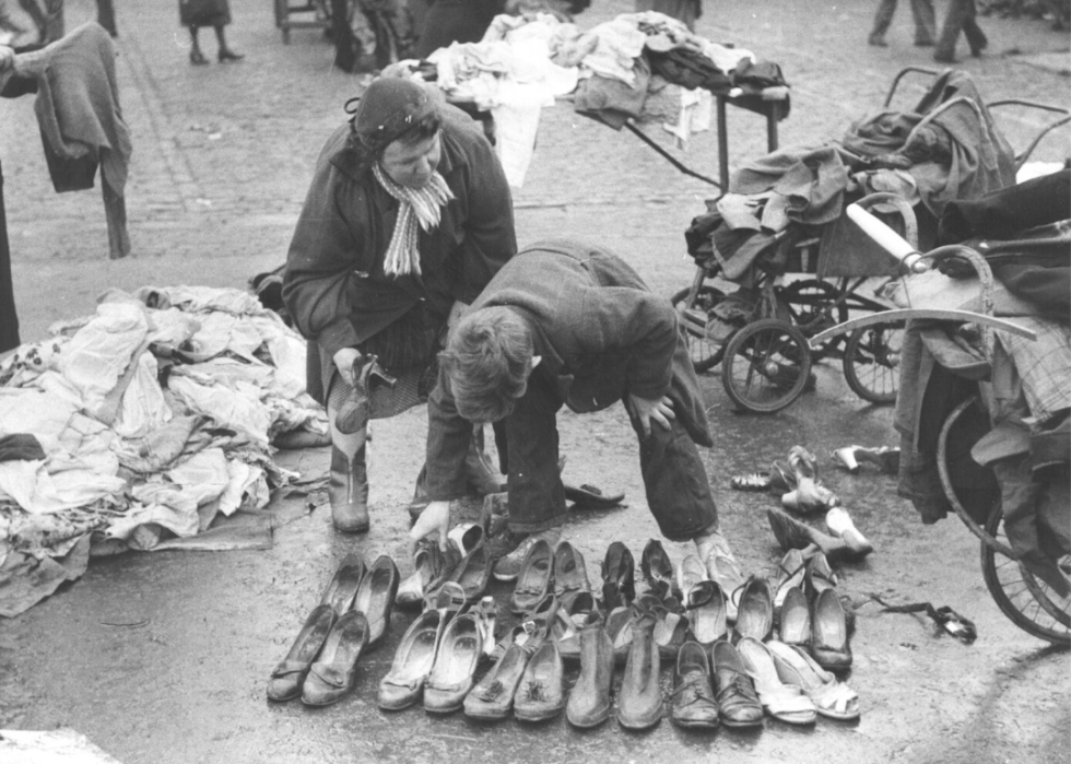 Person buying secondhand shoes on the street.
