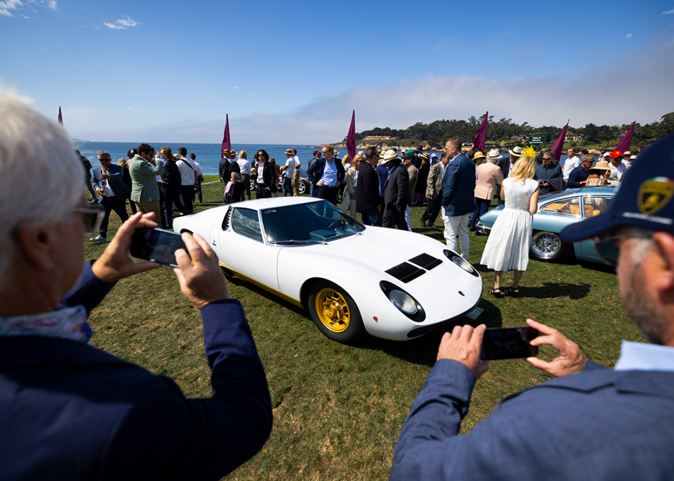 Attendees view cars on display at at Pebble Beach.