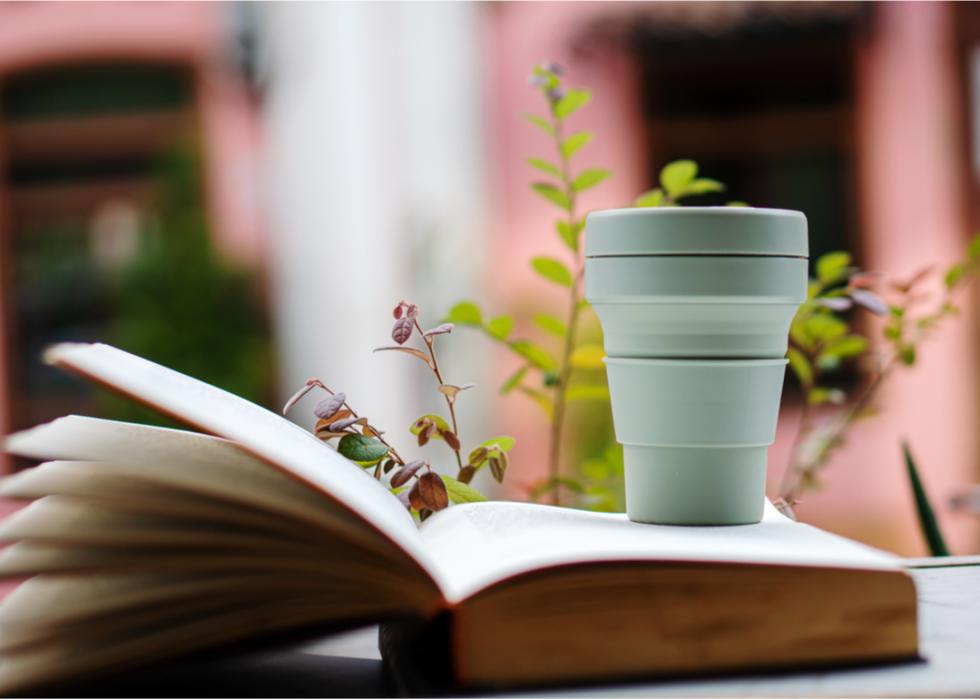 Reusable silicone coffee cup on open book