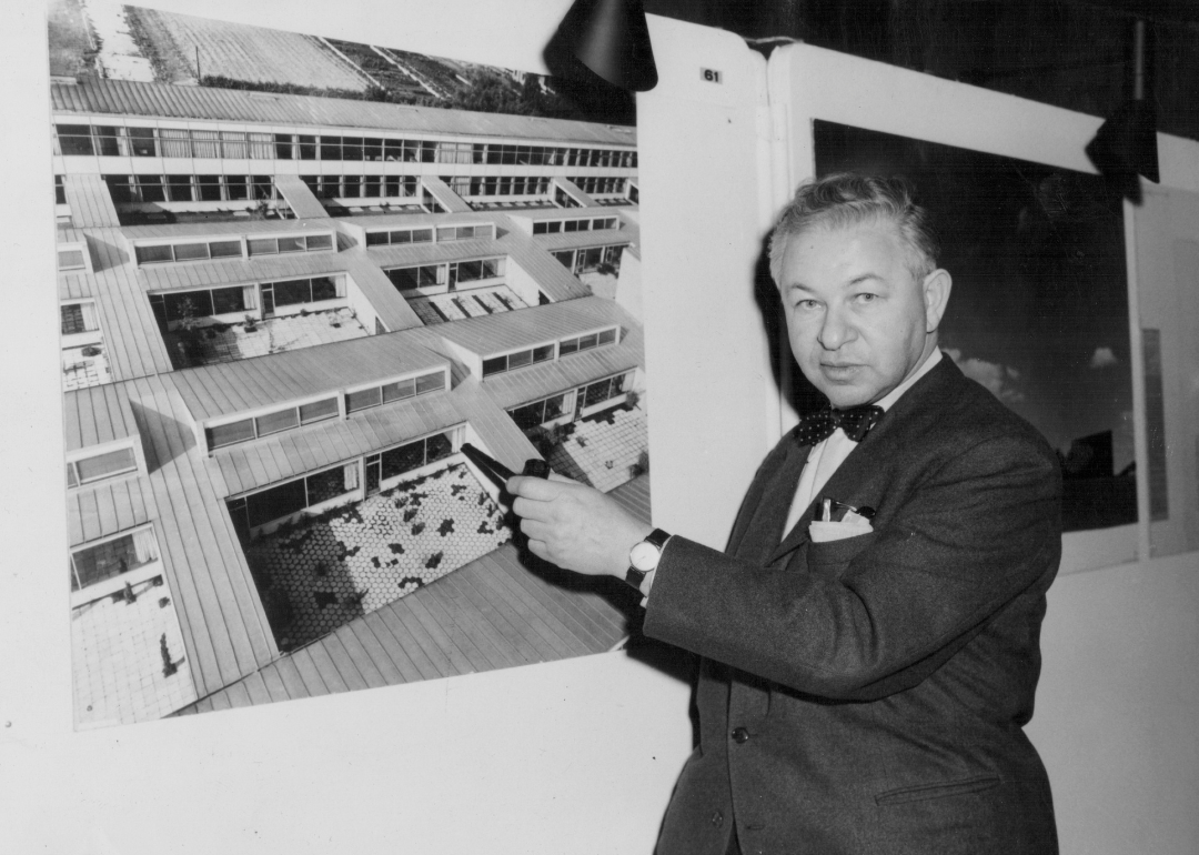 Arne Jacobsen pointing at a picture of one of the schools he designed.