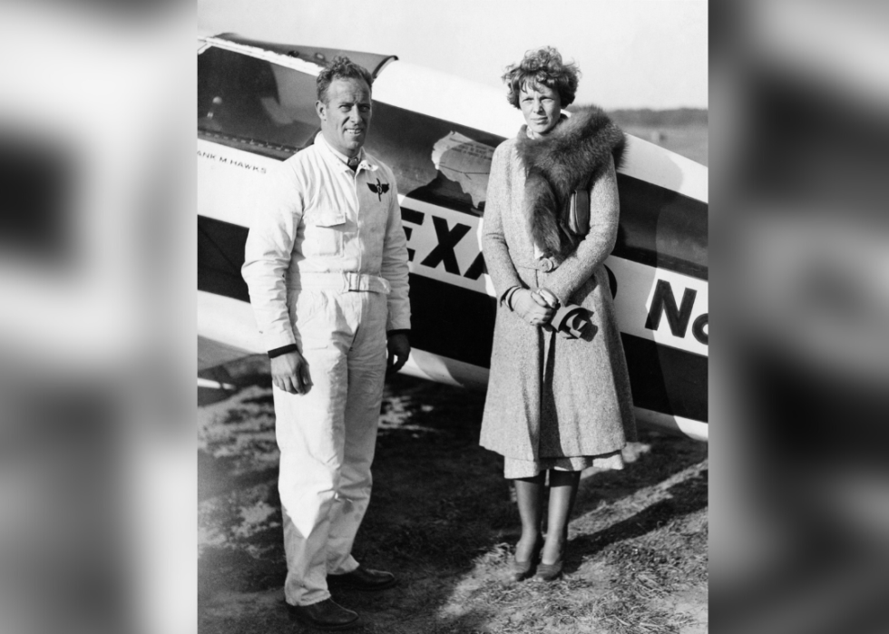 Amelia Earhart and Captain Frank Hawk posed by plane