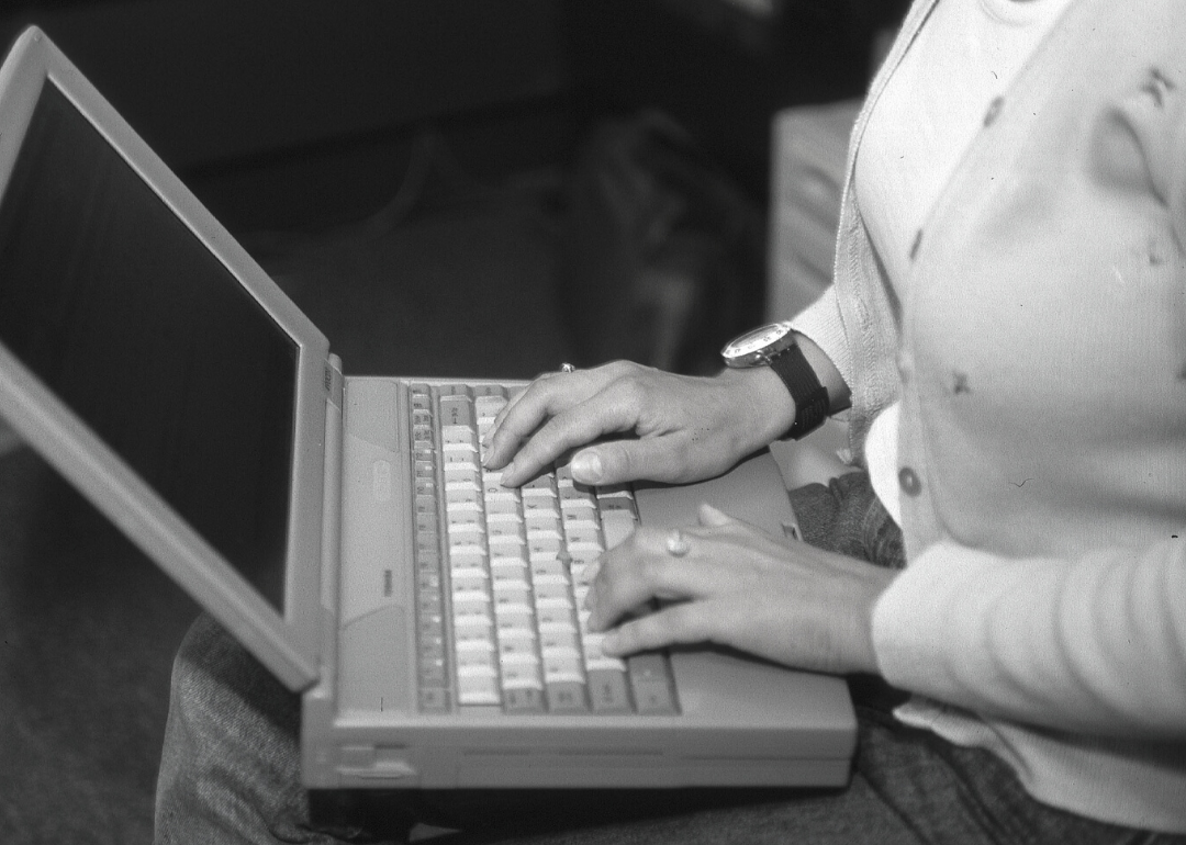 Woman’s hands type on a laptop computer