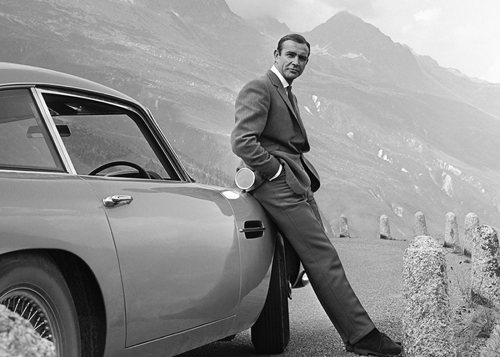 Sean Connery poses as James Bond next to his Aston Martin DB5.