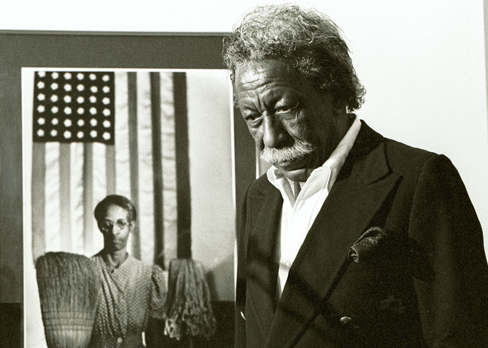 Gordon Parks stands next to one of his most famous images 'American Gothic’.