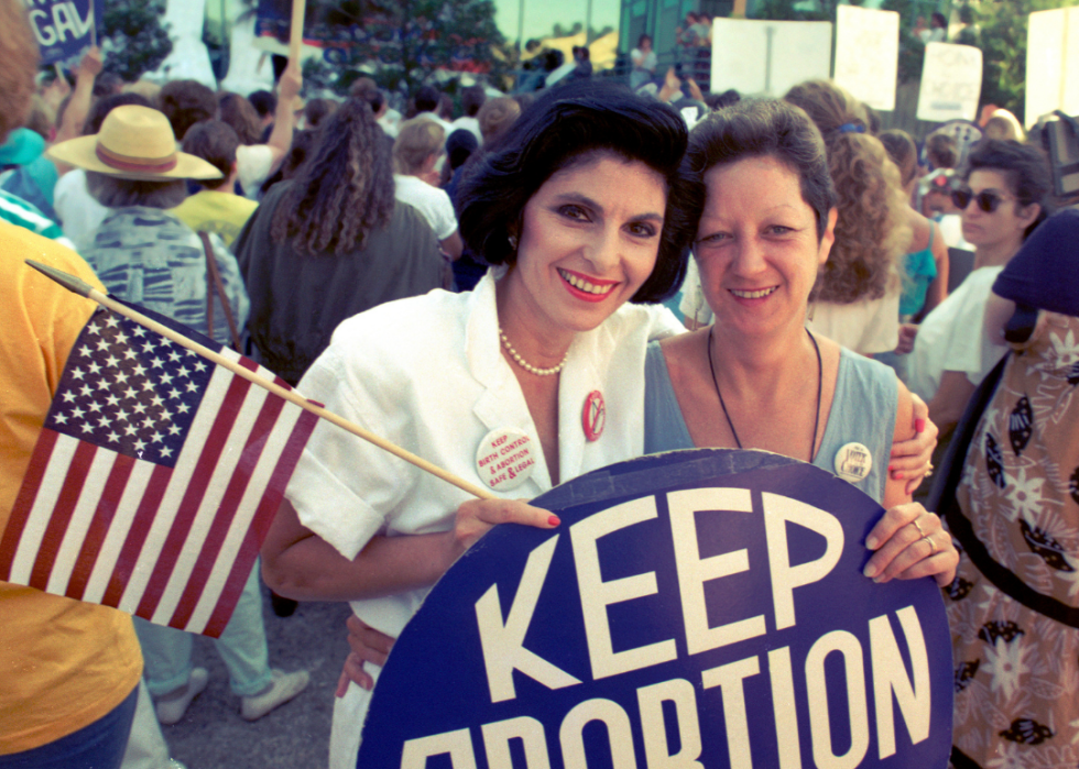 Attorney Gloria Allred and Norma McCorvey ‘Jane Roe’ hold sign and flag