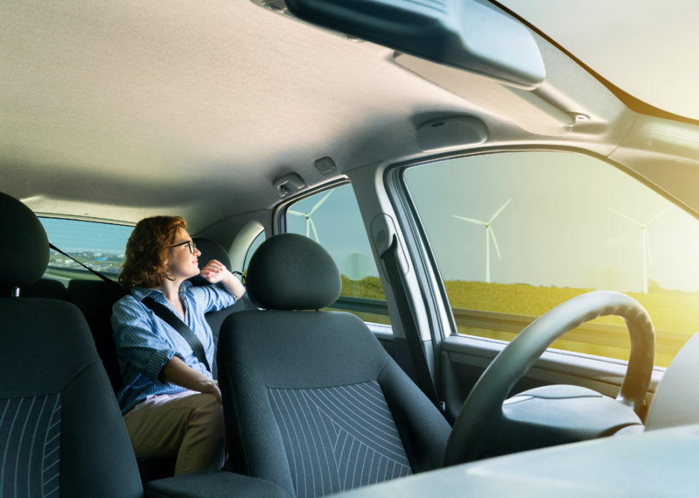 Person in back seat of futuristic self driving car.