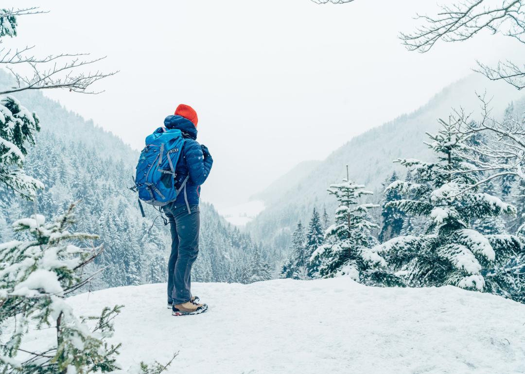 Backpacker standing in snowy mountain landscape