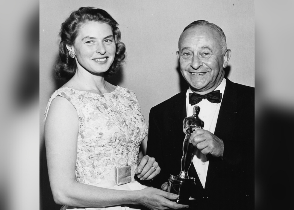 Arthur Freed holding an Oscar beside Ingrid Bergman at the Academy Awards.