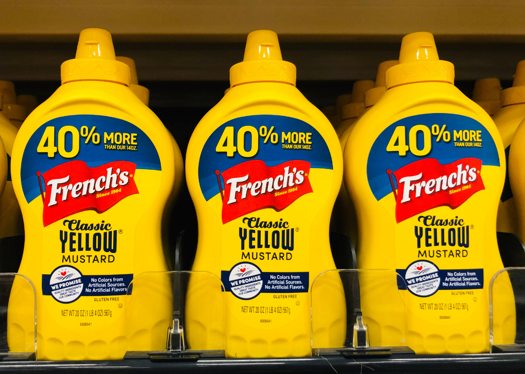Bottles of mustard on grocery store shelf.
