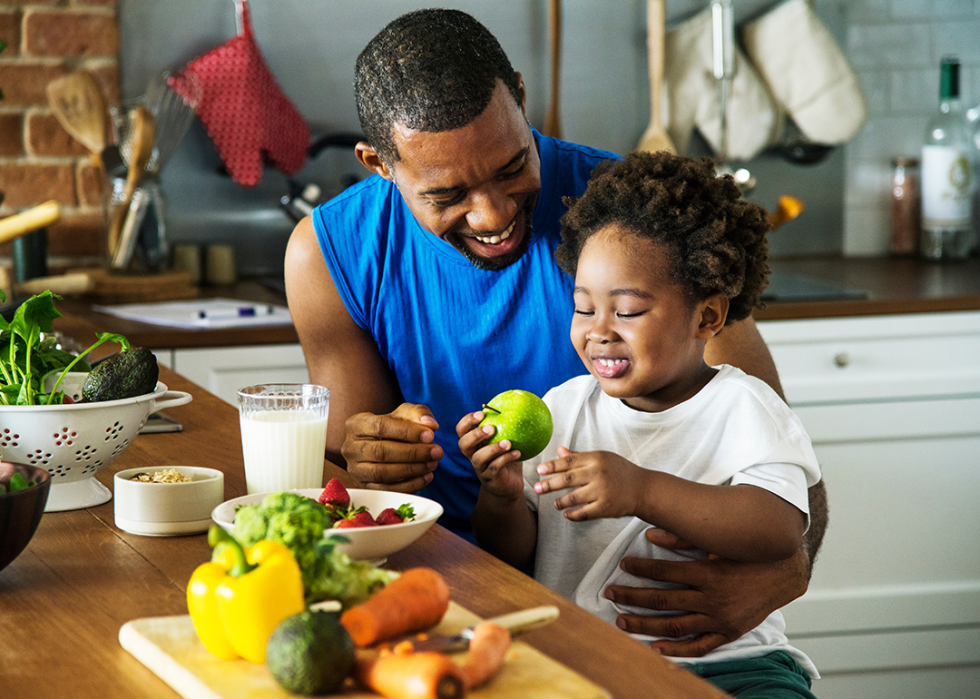 A father and toddler-aged son preparing a healthy meal.