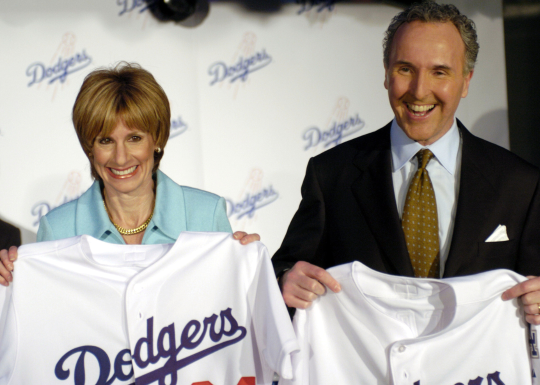 Frank McCourt and Jamie Luskin hold Dodgers jerseys at a press conference