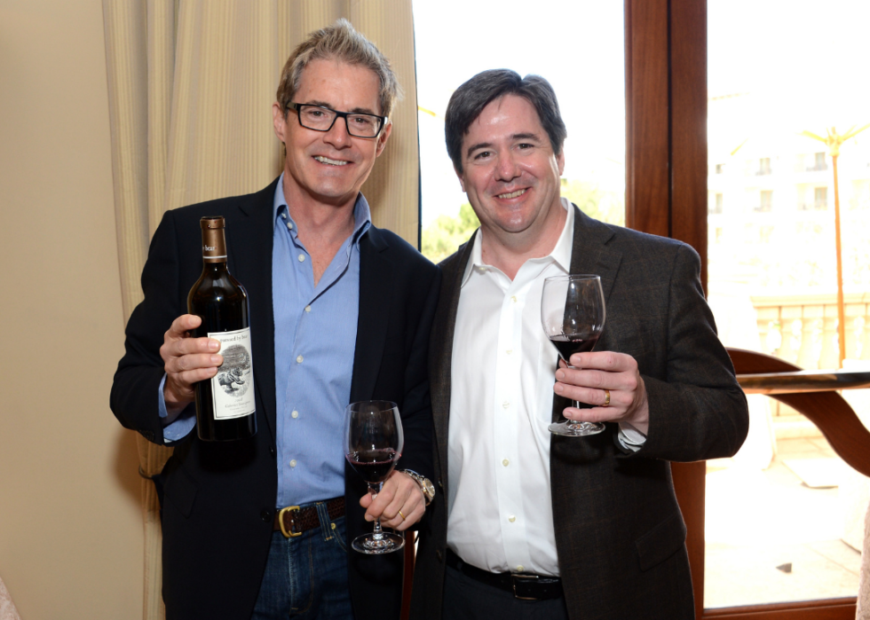 Kyle MacLachlan and Ray Isle, Executive Wine Editor, Food & Wine pose at event with wine.