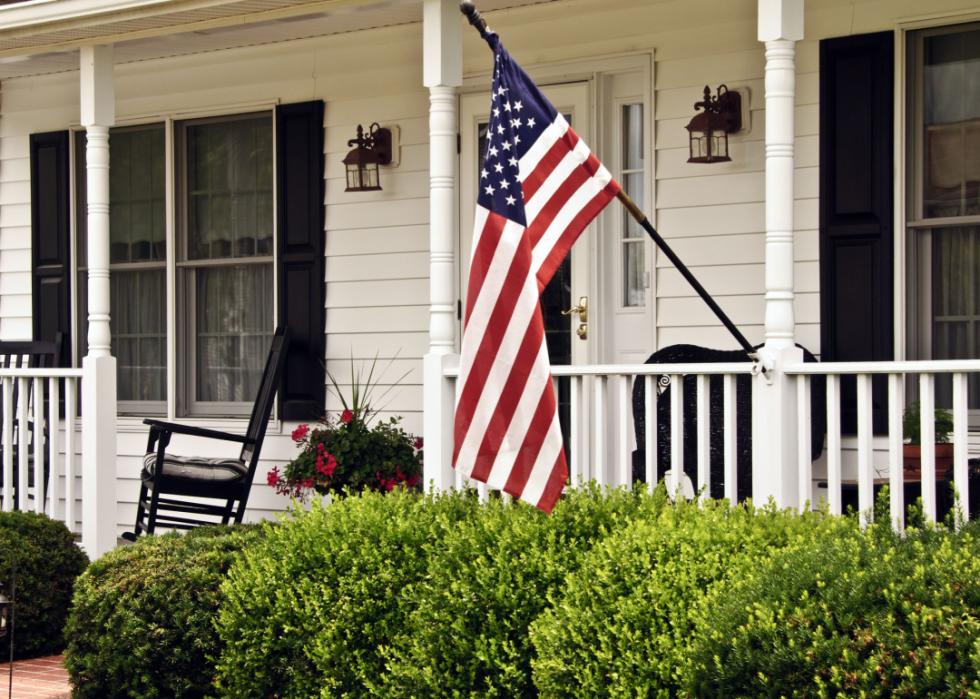 Front porch of colonial home with American Flag.