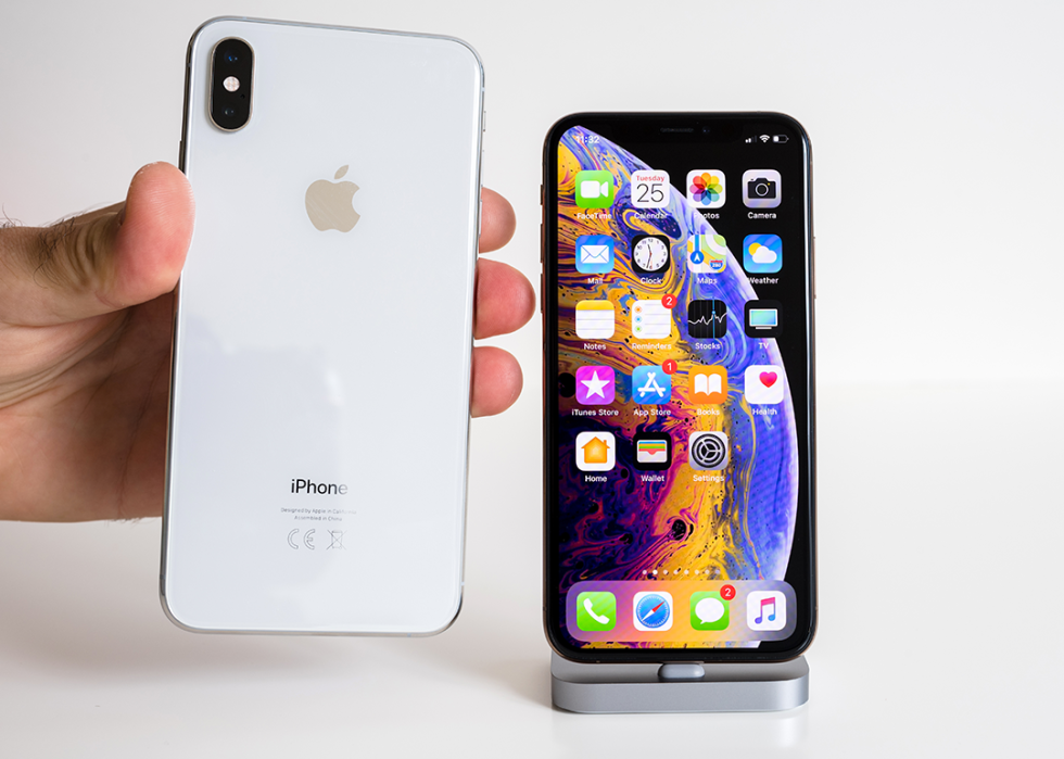 Hand comparing iPhone Xs and Xs Max.