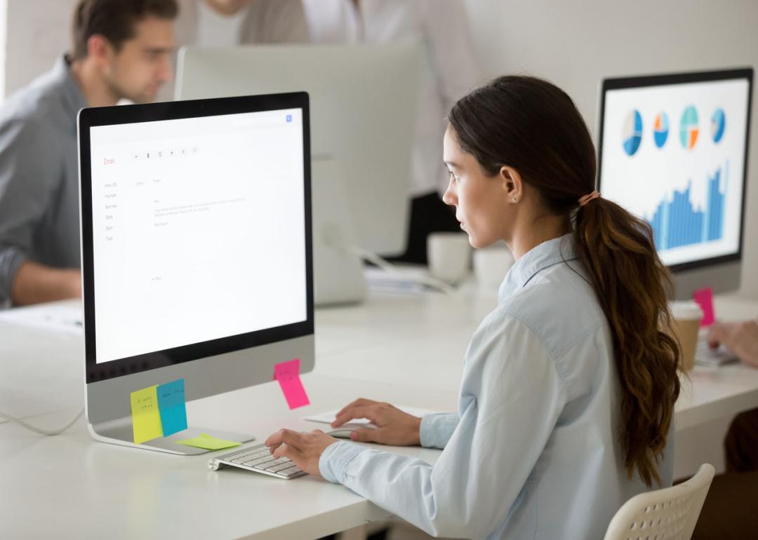 Woman in office composing email.