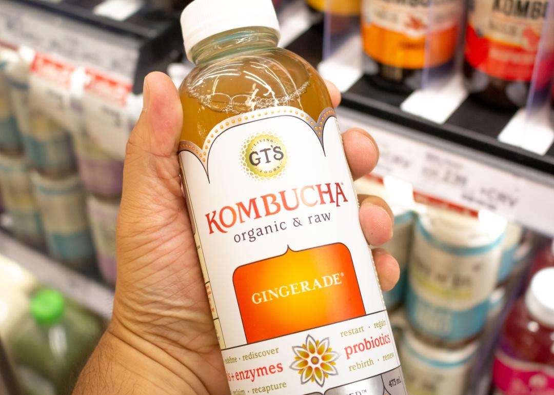 Hand holding a bottle of GT’s Living Foods Kombucha.