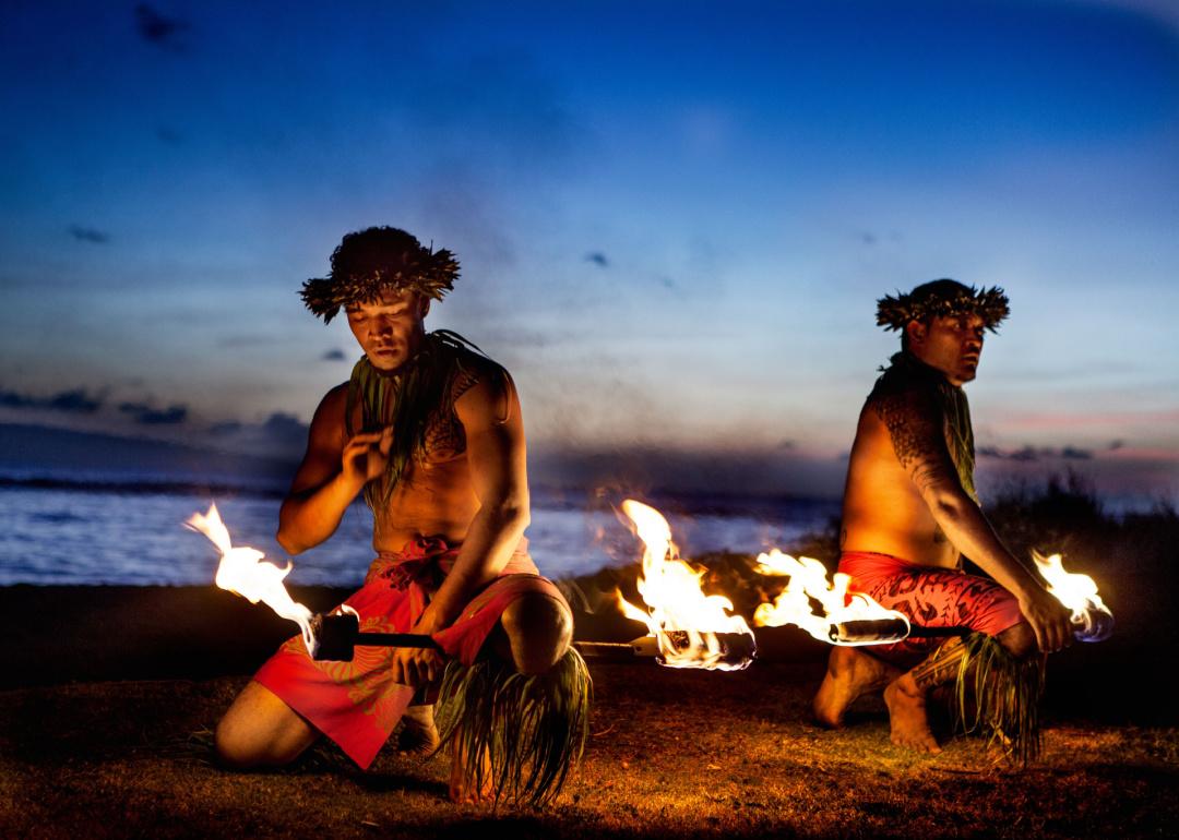 Two Hawaiian men preparing for traditional fire dance