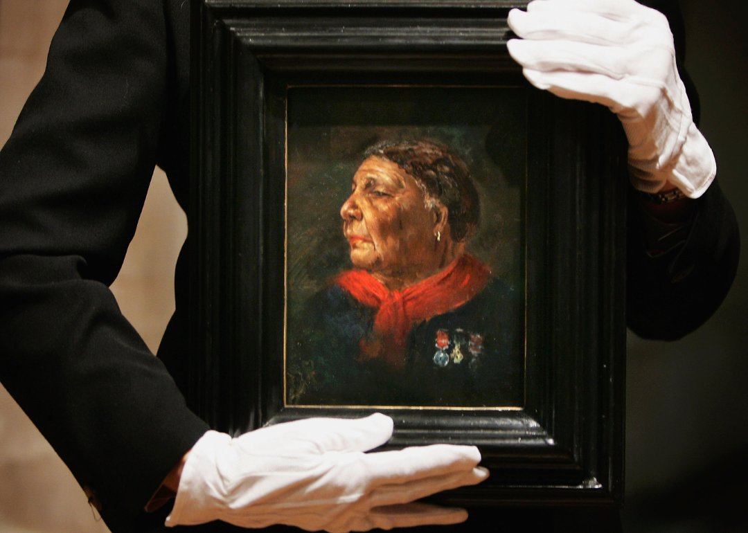 A historian holds a portrait of Mary Seacole by Albert Challen.