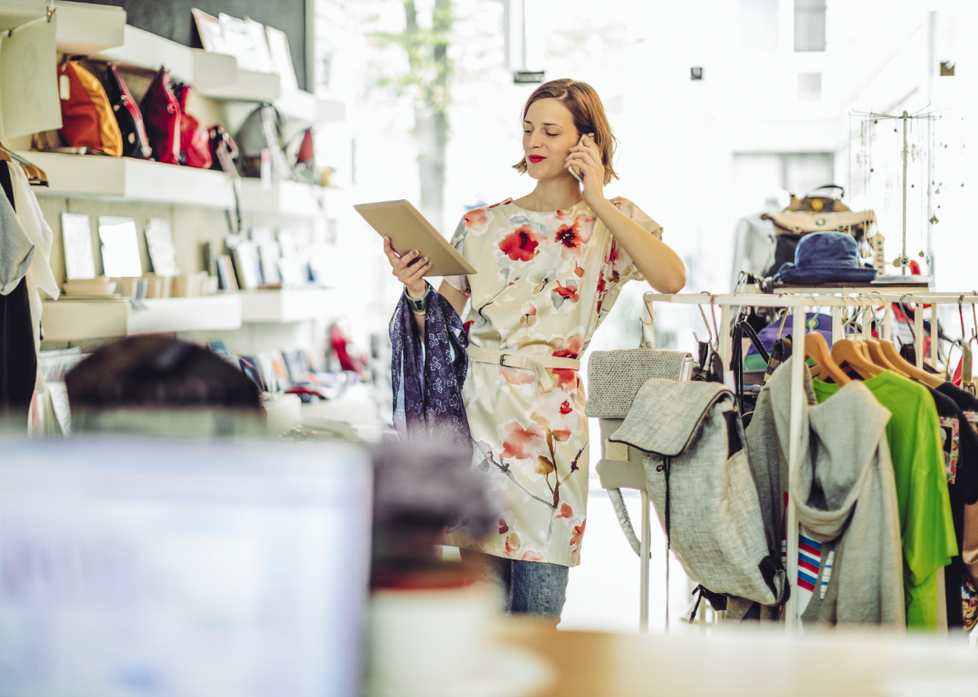 Fashion designer looking at tablet in retail shop.