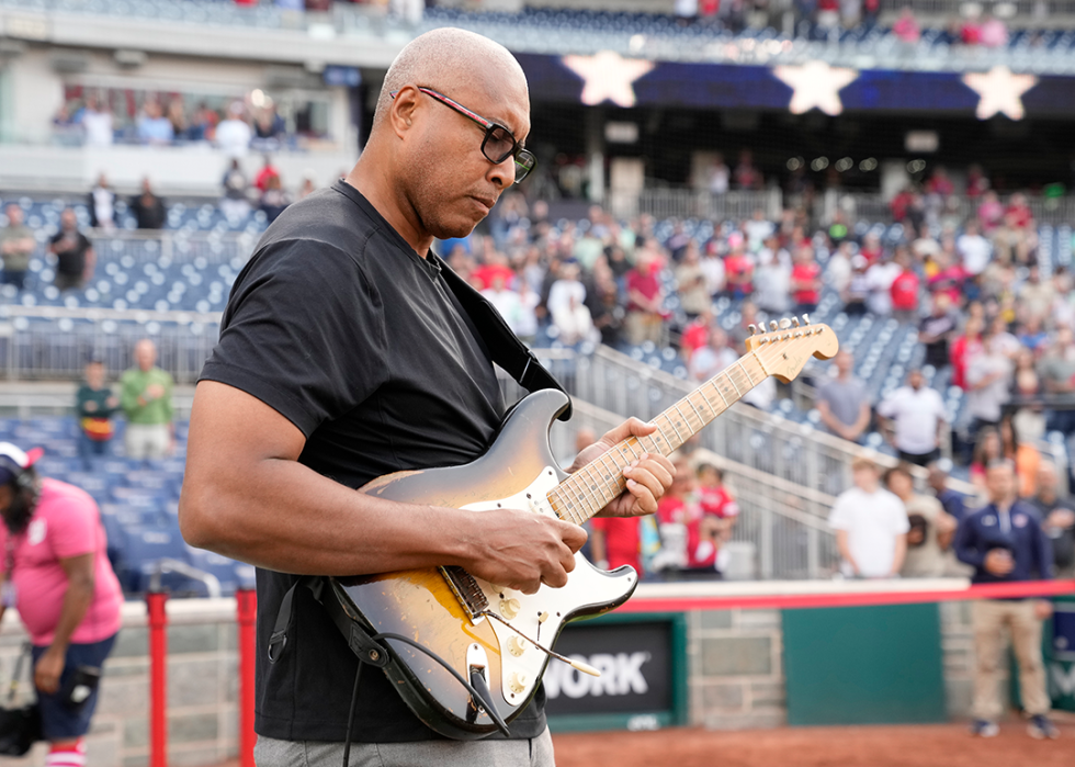 Bernie Williams plays the National Anthem on his guitar before a baseball game at Nationals Park.