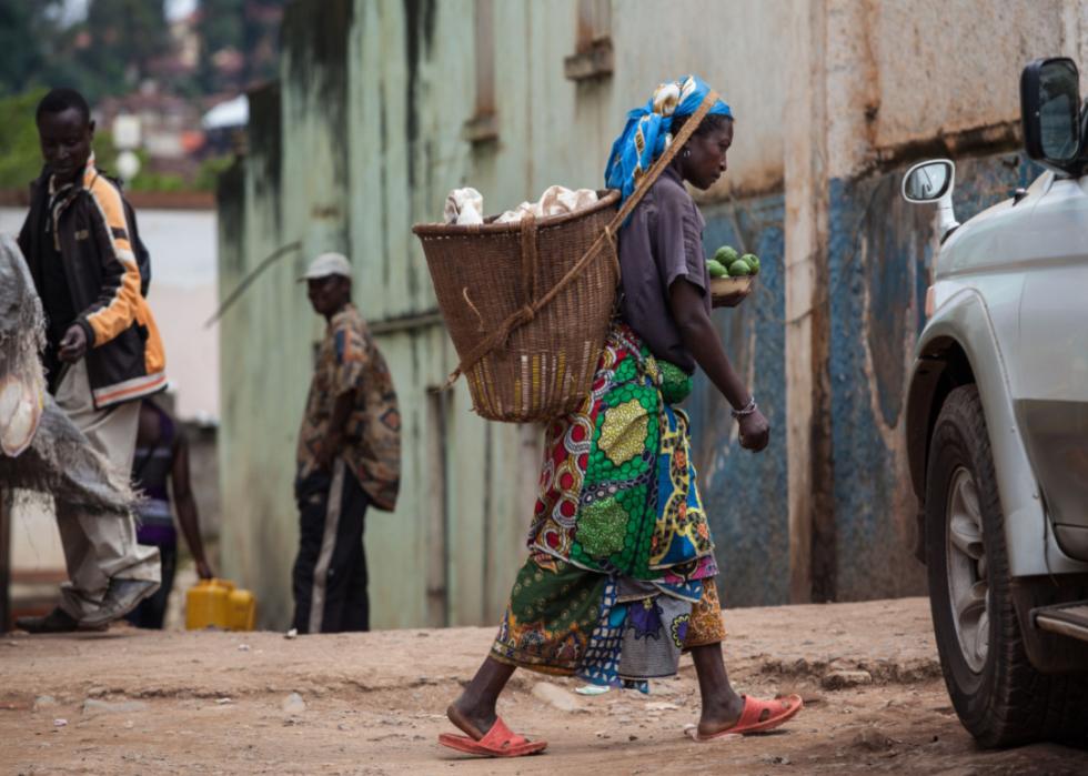 Woman carries basket through street in Bukavu