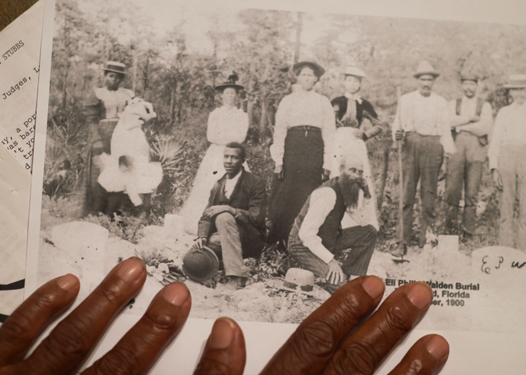 Hands hold archival photo showing burial of Rosewood victim