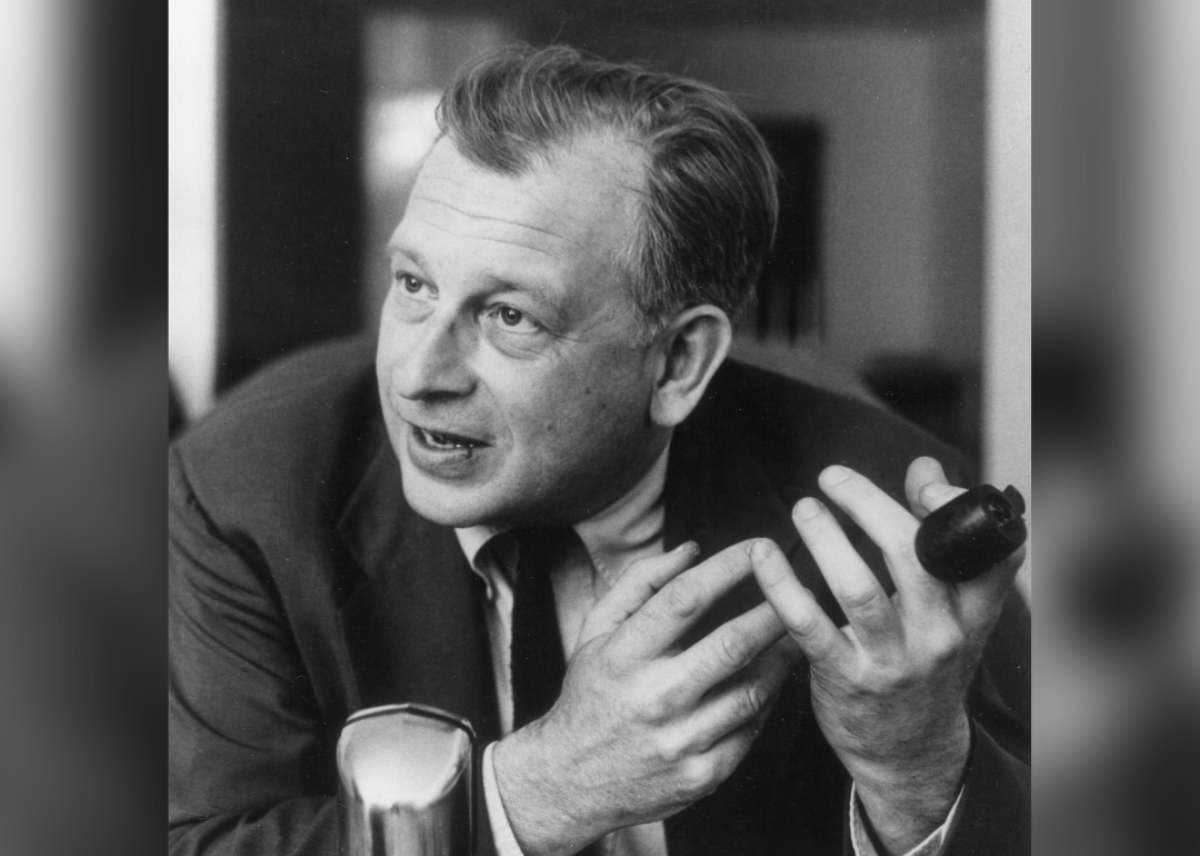 Eero Saarinen talks into a microphone holding pipe.