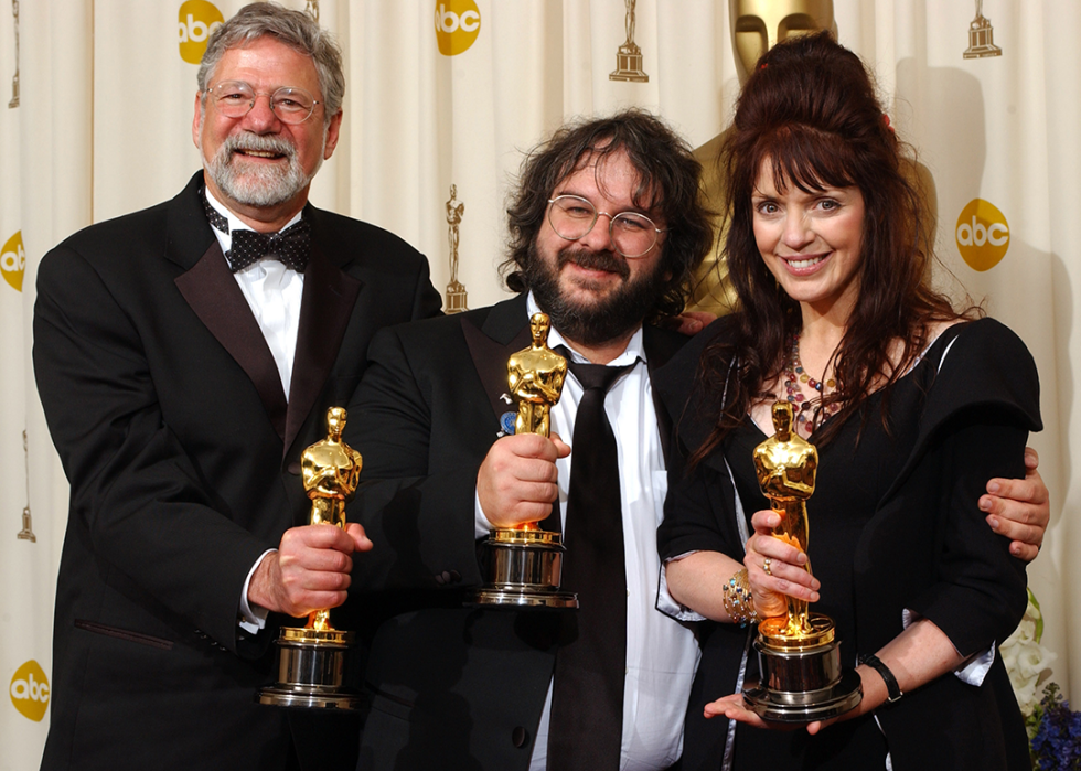 Barrie M. Osborne, Peter Jackson, and Fran Walsh pose with Academy Awards.
