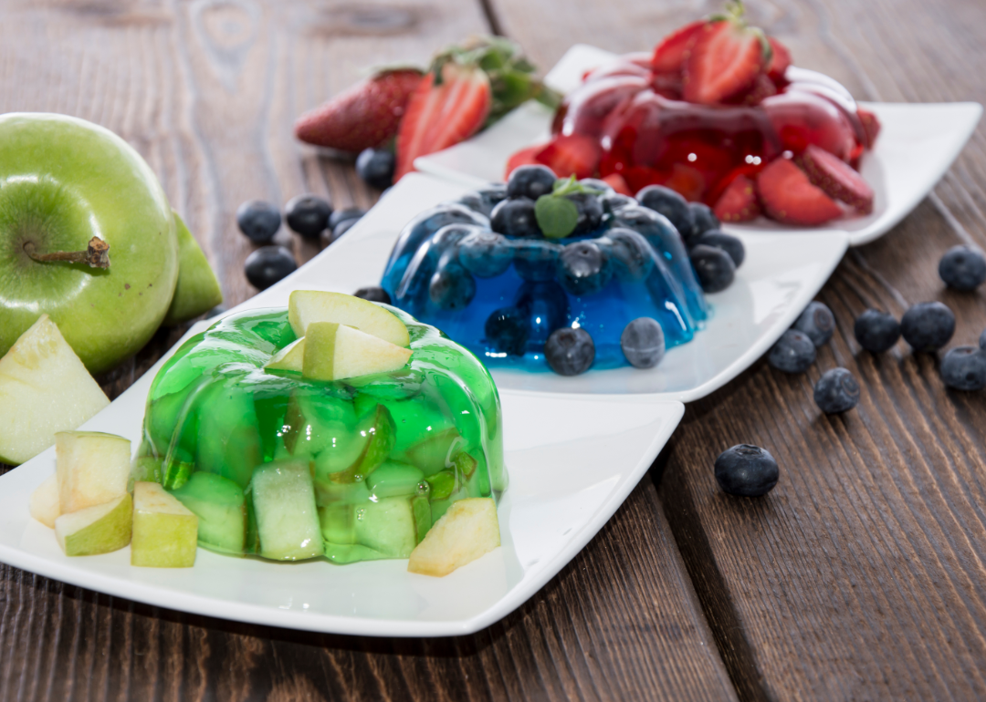 Red, blue, and green jello molds with fruit.