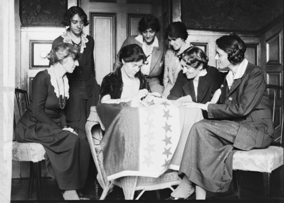 National Women's Party leaders watch as Alice Paul sews a ratification star on the suffrage flag