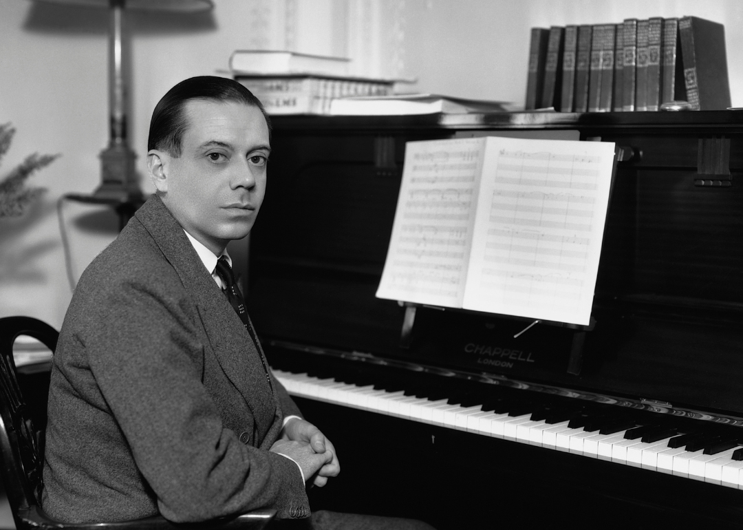 Cole porter sits at piano.