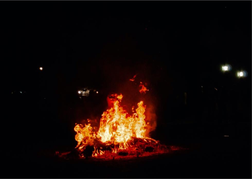 A bonfire with a burning figure in it at night.