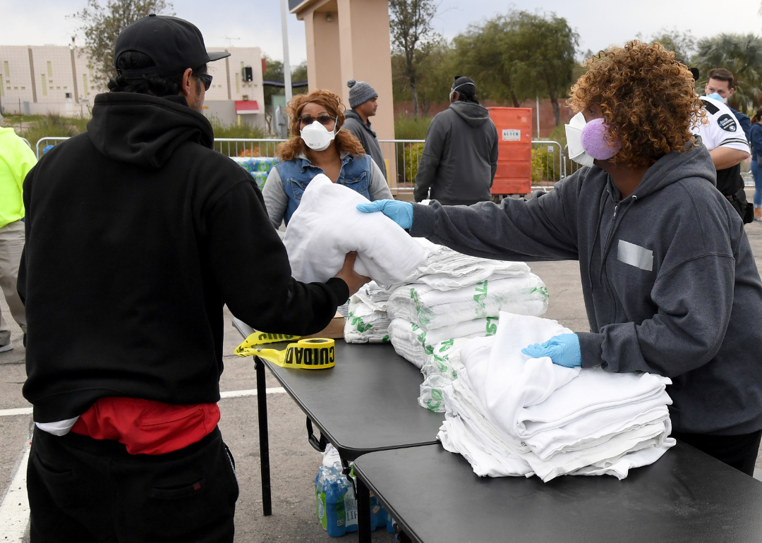 Workers wearing masks hand out blankets at a temporary homeless shelter in Las Vegas