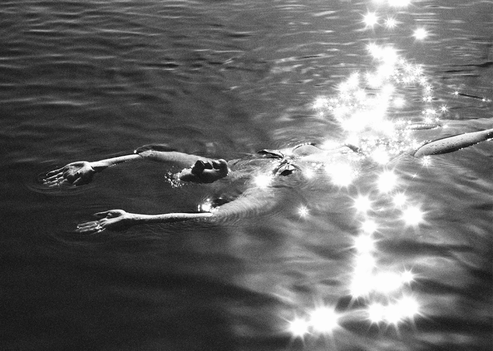 A woman relaxes as she floats at sunset in a Norwegian lake.